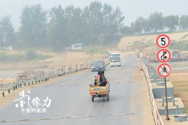 濟南北店子黃河浮橋兩側也設有提示牌，禁止自行車上橋，一輛三輪車慢慢駛向?qū)Π?。（圖文 李瑞平）