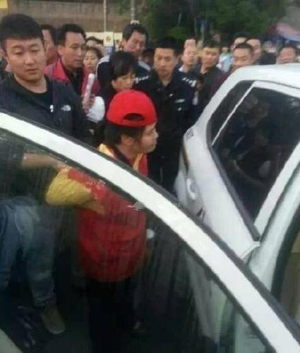 女志愿者被民警帶上警車，受傷女子則被送醫(yī)救治。