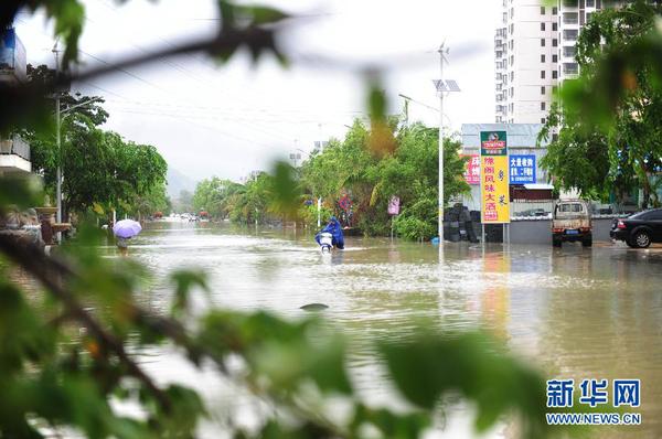 6月23日，在海南省三亞市，人們?cè)诜e水路段涉水前行。今年第8號(hào)臺(tái)風(fēng)“鯨魚”已于6月22日18時(shí)50分左右在海南省萬寧市沿海登陸，臺(tái)風(fēng)給三亞帶來了強(qiáng)風(fēng)降雨天氣，影響市民正常出行。新華社發(fā)（沙曉峰 攝）