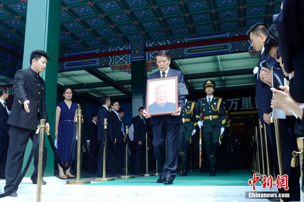 7月22日，萬里遺體在北京火化，社會各界人士前往八寶山殯儀館進(jìn)行悼念。圖為萬里兒子萬伯翱手捧遺像步出。 中新社發(fā) 盛佳鵬 攝