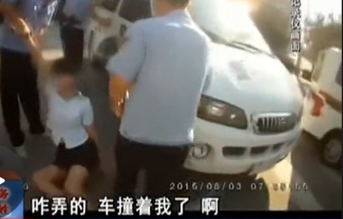 在拉扯中，女子撞到警車上。