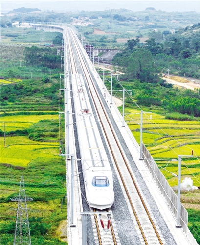 　12月3日，一輛試運行的“和諧號”列車從廣西南寧市隆安縣境內的一座高架橋經過。韋萬忠攝（新華社發(fā)）