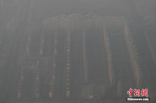 資料圖：2015年12月21日，北京上空航拍空氣重污染，地面建筑若隱若現(xiàn)。12月18日，北京再次發(fā)布紅色預(yù)警，12月19日7時(shí)至12月22日24時(shí)啟動(dòng)空氣重污染紅色預(yù)警措施。實(shí)施機(jī)動(dòng)車單雙號(hào)行駛、建議中小學(xué)幼兒園停課等措施。 <a target='_blank' href='http://www.chinanews.com/'>中新社</a>記者 廖攀 攝