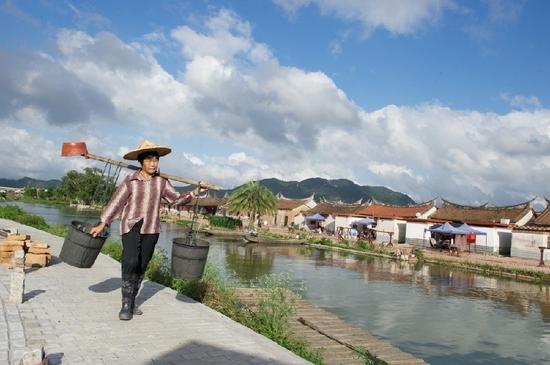 5月27日，埭美村一位村民挑桶經(jīng)過村前小河