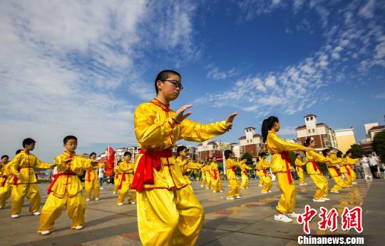 身著黃色統(tǒng)一古式服裝的少年打太極拳。　傅建斌　攝