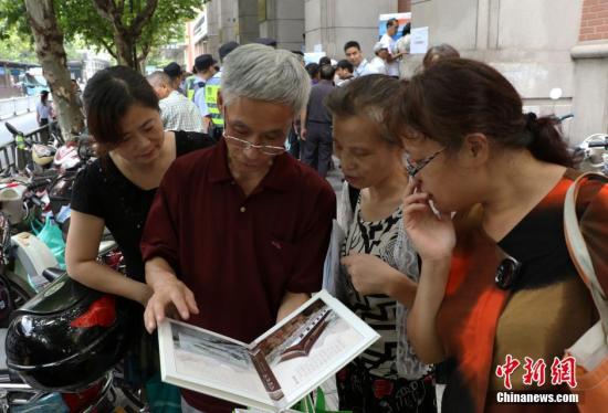 資料圖：幾位杭州市民欣賞已買到的“G20杭州峰會(huì)明信片”。 中新社記者 王剛 攝