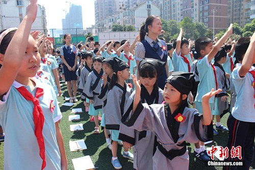 　　8月29日，長(zhǎng)沙市岳麓區(qū)一小學(xué)舉行開(kāi)學(xué)典禮，一年級(jí)新生們身著漢服，在老師的帶領(lǐng)和高年級(jí)同學(xué)的幫助下完成了“開(kāi)筆禮”。校方希望以此方式教育學(xué)生從小要立志、做好人，學(xué)會(huì)感恩老師，勇于表達(dá)。劉著之 攝