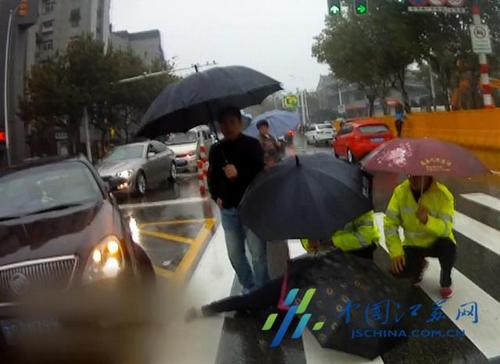 江蘇徐州女子雨中被撞倒地 民警為其撐傘遮雨