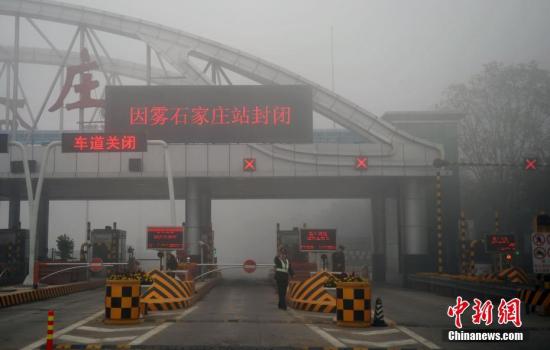 11月3日，受大霧影響，位于京港澳高速石家莊裕華路收費站高速入口已經(jīng)關(guān)閉，交警在入口處設(shè)置圍擋，并疏導(dǎo)過往車輛。該省氣象臺發(fā)布大霧橙色預(yù)警信號，保定、廊坊及以南大部分地區(qū)有能見度低于200米的濃霧。 中新社記者 翟羽佳 攝