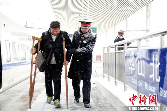 圖為鐵路工作人員幫助旅客進(jìn)站。　秦姝　攝