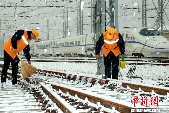 圖為鐵路工作人員進(jìn)行鐵軌防凍除雪工作。　王曙天　攝