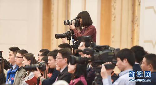 3月7日，一名女記者在十二屆全國人大五次會(huì)議江蘇代表團(tuán)全體會(huì)議上采訪拍攝。在兩會(huì)會(huì)場內(nèi)外，女代表、女委員、女工作人員、女記者在工作中盡職盡責(zé)，展現(xiàn)著自己的風(fēng)采。 新華社記者陳曄華攝