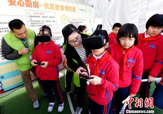 活動現(xiàn)場，小學生通過VR(虛擬現(xiàn)實)技術設備模擬廚房場景，在互動中學習生熟分開，菜品搭配與油鹽使用的廚房食品安全知識。　記者劉可耕 攝