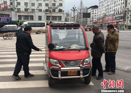 營山城區(qū)電動四輪車司機(jī)正在討論車輛的車況。　劉忠俊 攝