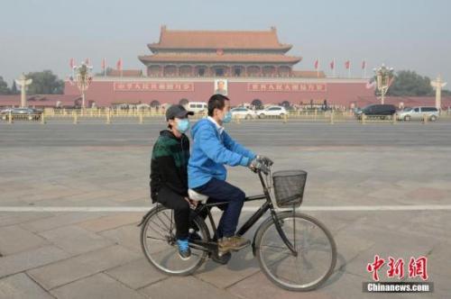 資料圖：一對(duì)青年佩戴口罩騎車經(jīng)過北京天安門廣場(chǎng)。 <a target='_blank' href='http://www.chinanews.com/'>中新社</a>記者 崔楠 攝