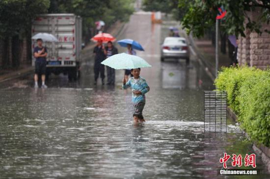 6月12日，市民在積水的道路中出行。當(dāng)日，貴陽市氣象臺于6時28分將暴雨黃色預(yù)警信號升級為暴雨紅色預(yù)警信號，持續(xù)降雨造成貴陽市多處路段嚴重積水。<a target='_blank' href='http://www.chinanews.com/'>中新社</a>記者 賀俊怡 攝