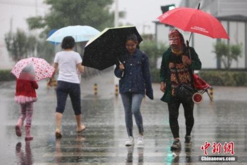 資料圖：民眾在雨中出行。