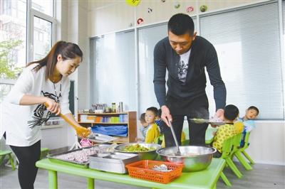 逄秋香、陳亮夫妻倆為幼兒園孩子盛午飯。