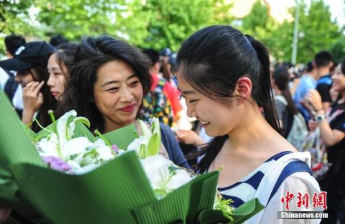 資料圖：山東濟(jì)南眾多考生手捧鮮花在家長的簇?fù)硐職g快告別高考。<a target='_blank' href='http://www.chinanews.com/' _fcksavedurl='http://www.chinanews.com/'></table>中新社</a>記者 張勇 攝