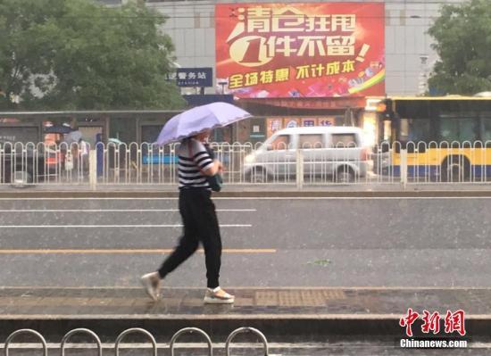 6月23日清晨，北京市民冒雨出行。 中新網(wǎng)記者 富宇 攝