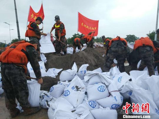 武警部隊(duì)利用沙包和挖機(jī)加固堤壩 胡徐峰 攝