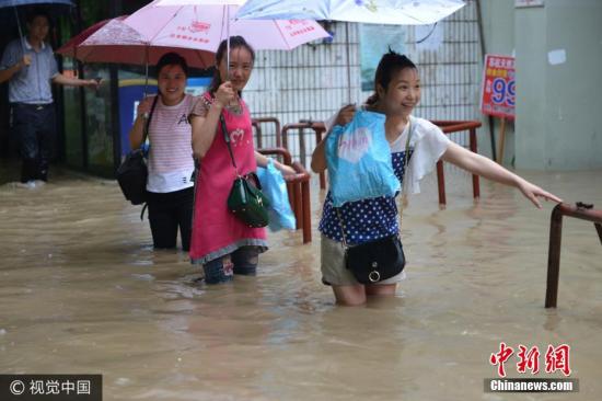 圖為南京市雨花臺(tái)區(qū)，市民在水中艱難出行。圖片來源：視覺中國(guó)