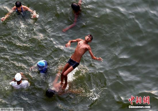 今年夏天，世界各地迎來(lái)持續(xù)高溫天氣。世界氣象組織(WMO)指出，在觀測(cè)歷史上最熱的2016年的氣候現(xiàn)象后，專家預(yù)計(jì)今年也將持續(xù)或多發(fā)熱浪及大雨等極端天氣，主要是由于溫室氣體濃度和海水表面溫度的上升加劇了全球變暖。世界各地紛紛進(jìn)入“燒烤模式”。圖為當(dāng)?shù)貢r(shí)間6月16日，印度阿拉哈巴德，一名男孩在亞穆納河嬉水。