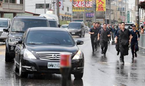 蔡英文6日南下高雄燕巢天后宮參拜，遭到軍公教人士群聚抗議，車隊抵達(dá)現(xiàn)場時維安人員跑在車隊旁戒護(hù)。(圖片來源：臺灣“中時電子報”)