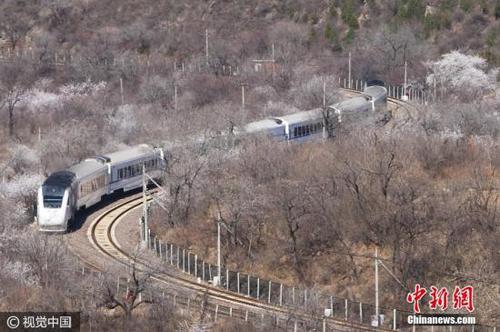 2017年3月26日，北京居庸關長城腳下，山花漸次盛開，和諧號列車行駛在花海中，駛向春天，美如畫卷。王明允 攝 圖片來源：視覺中國