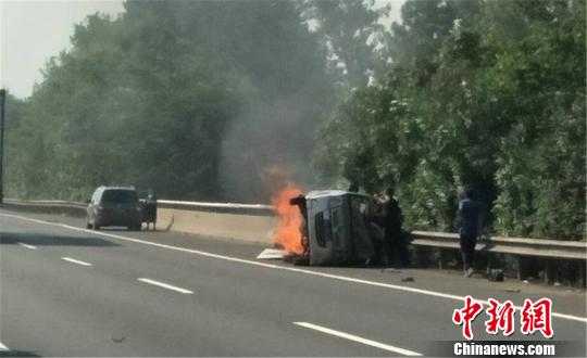 圖為：杭甬高速寧波段一輛面包車側(cè)翻后起火，好心人救一家7口。　何蔣勇 攝