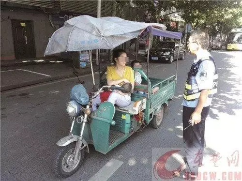 年輕母親邊開三輪邊喂奶 交警沒罰款還一路護送