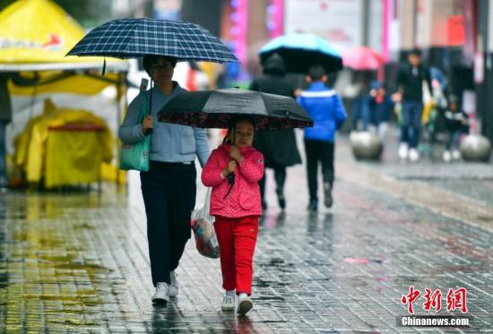 資料圖：9月24日，新疆烏魯木齊市降下秋雨，外出民眾打著雨傘快步前行。 <a target='_blank' href='http://www.chinanews.com/'>中新社</a>記者 劉新 攝