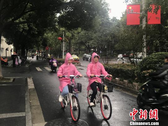 11日，南京迎來降溫降雨。圖為市民披上雨衣出行。　楊顏慈 攝