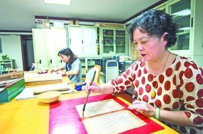 武漢市圖書館的古籍修復(fù)非遺傳承人賀琳在補缺口