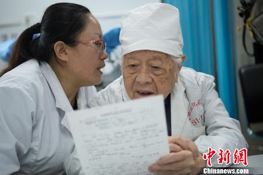 問診時(shí)，她的助手王利花趴在于載畿耳朵旁當(dāng)“傳聲筒”，書寫病歷時(shí)，于載畿用尺子比著。　武俊杰 攝