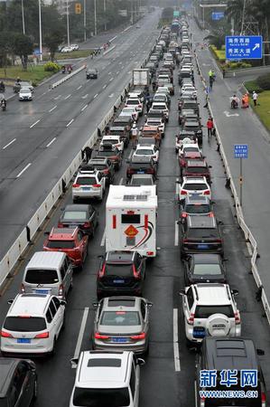 2月23日，車輛在海口市丘海大道排隊(duì)等待入港登船。