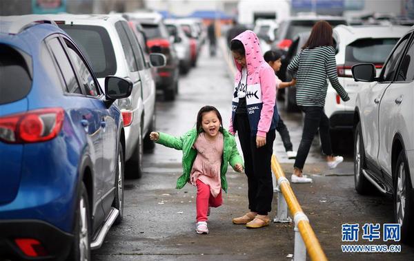 2月23日，小朋友在海口港的車輛等候區(qū)玩耍。