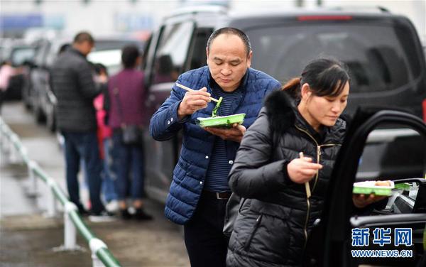 2月23日，滯留旅客在海口港吃午飯。