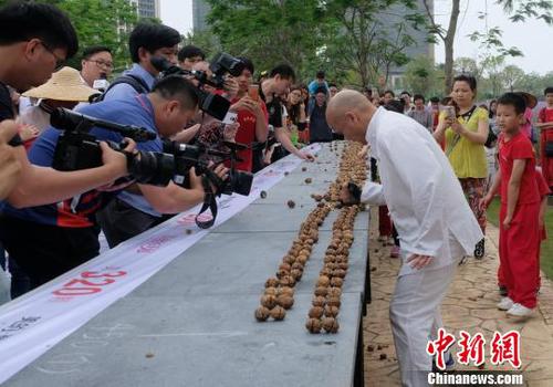 黎偉軍手劈核桃現(xiàn)場吸引不少人圍觀?！〕叹皞?攝