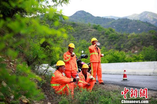 臨近中午，楊衛(wèi)東和工友們在路旁休息時(shí)，拿出自帶的干糧和水補(bǔ)充體力?！⒗^東 攝