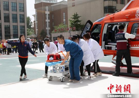 5月23日，遼寧省人民醫(yī)院完成中國(guó)東北首例異地航空醫(yī)療轉(zhuǎn)運(yùn)任務(wù)。圖為急救人員立即將患者抬上急救床?！≈烀饔?攝