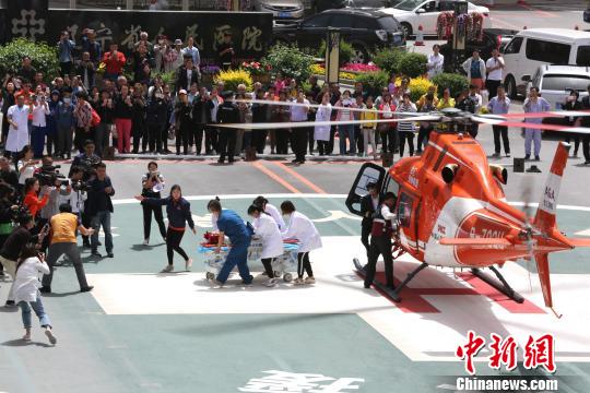 5月23日，遼寧省人民醫(yī)院完成中國(guó)東北首例異地航空醫(yī)療轉(zhuǎn)運(yùn)任務(wù)。圖為急救人員立即將患者抬上急救床?！≈烀饔?攝