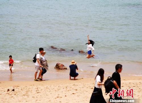 資料圖：端午假期，游客在三亞海邊嬉水。　王曉斌 攝