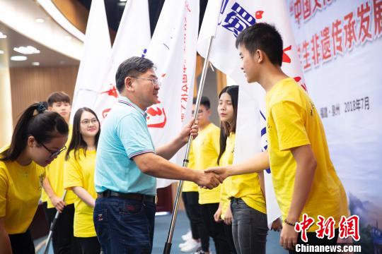 華僑大學校長助理張云波為2018年“中華文化之旅“6個研習營的學生代表授旗。伊凡 攝