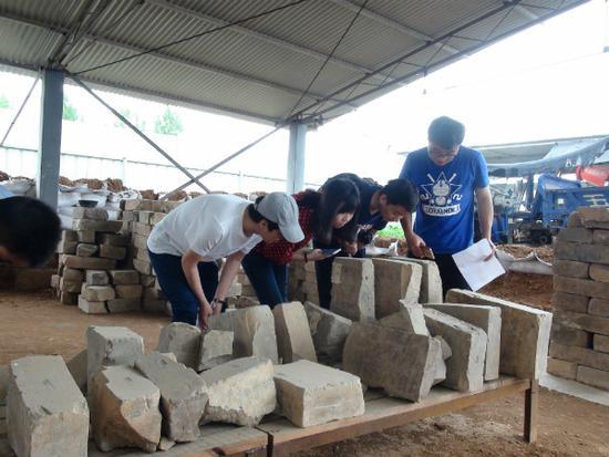 圖7 中國人民大學(xué)研究生在曹魏大墓工地現(xiàn)場考察出土墓磚（李重蓉攝影）