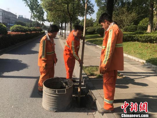 浙江省杭州市西湖區(qū)市政監(jiān)管科工作人員潘旭陽(左二)在清理淤泥。　胡哲斐 攝