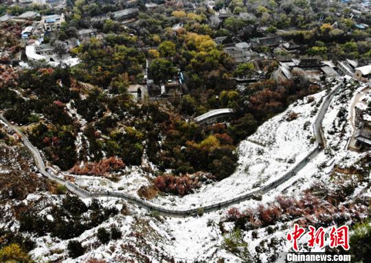 11月4日早晨，航拍視角中的蘭州城區(qū)一角，繽紛秋色中點(diǎn)綴著點(diǎn)點(diǎn)白雪?！钇G敏 攝