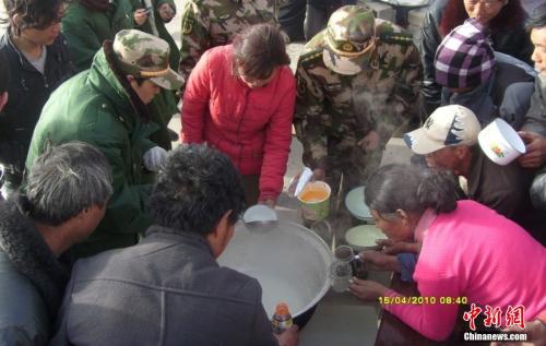 官兵在營地與災(zāi)民共同吃飯。武警玉樹支隊 趙飛 供圖