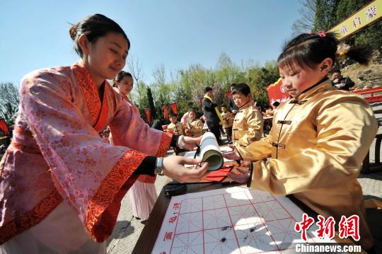 圖為曲阜舉行學(xué)童啟蒙開筆禮儀式?！∏肥形麄鞑抗﹫D 攝