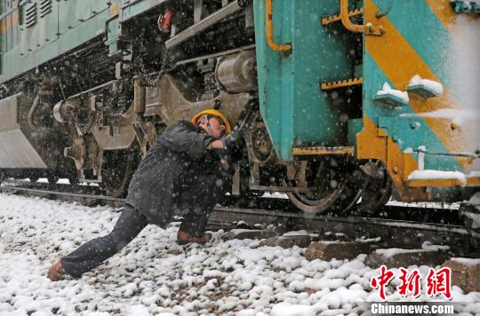 南京東機(jī)務(wù)段機(jī)車乘務(wù)員強(qiáng)化雪天機(jī)車走行部、車鉤等關(guān)鍵部件檢查，確保機(jī)車質(zhì)量良好，途中運輸安全。　劉金建 攝